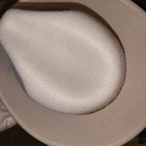 Fashion ivory hat with  gold chain around the brim.